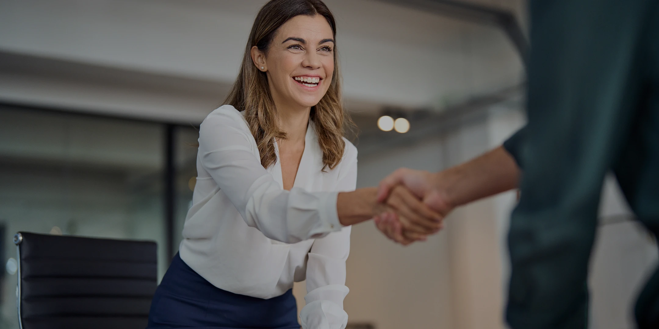Two people seal a deal with a handshake in a business environment