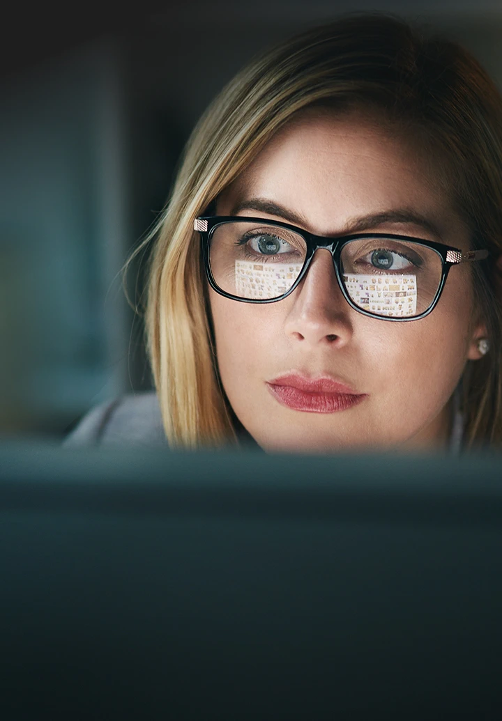 Business professional with glasses working diligently on a laptop