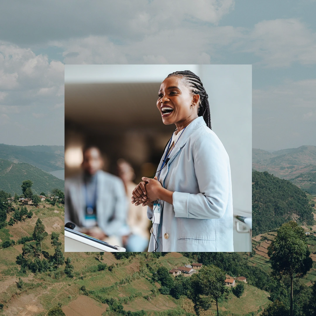 Woman with long dark hair, wearing a light blue blazer, speaking at a conference