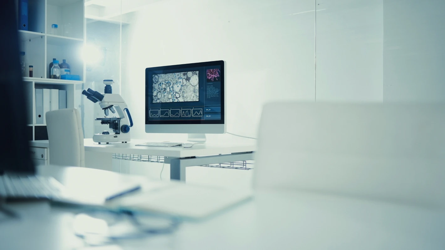 Clean, bright laboratory with a microscope and computer