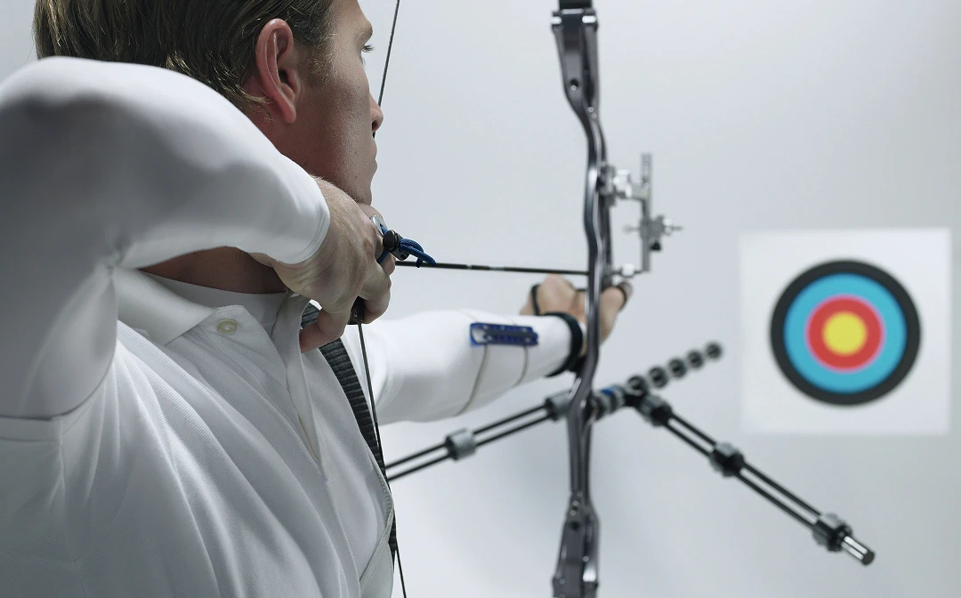 Archer aiming at target with bow and arrow