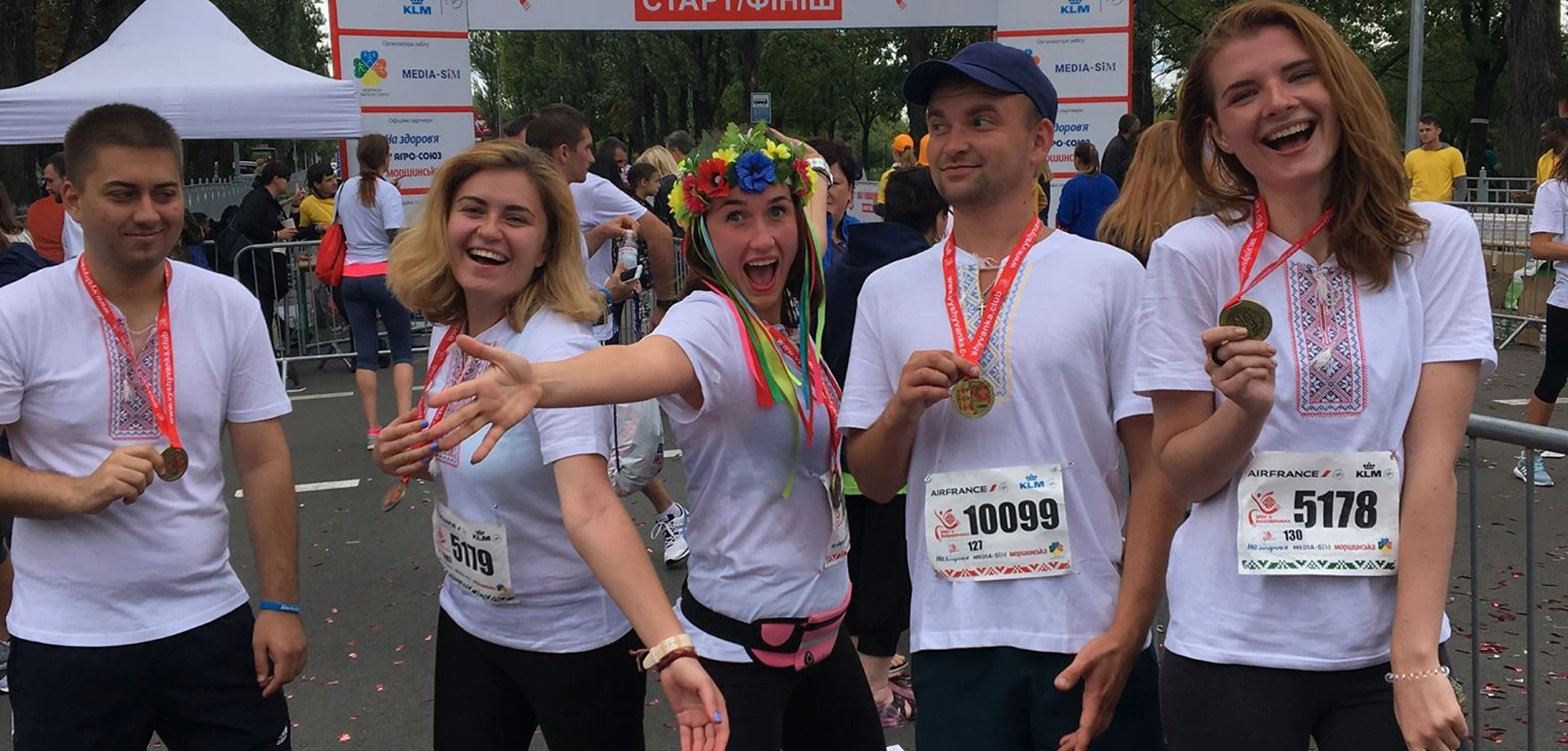 Five Ukrainian Helpware employees celebrate the finish of the marathon in traditional embroidered shirts
