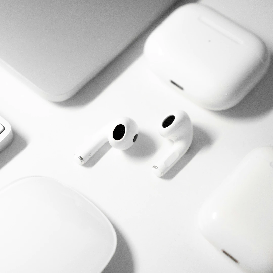 White earbuds and charging case on a white surface