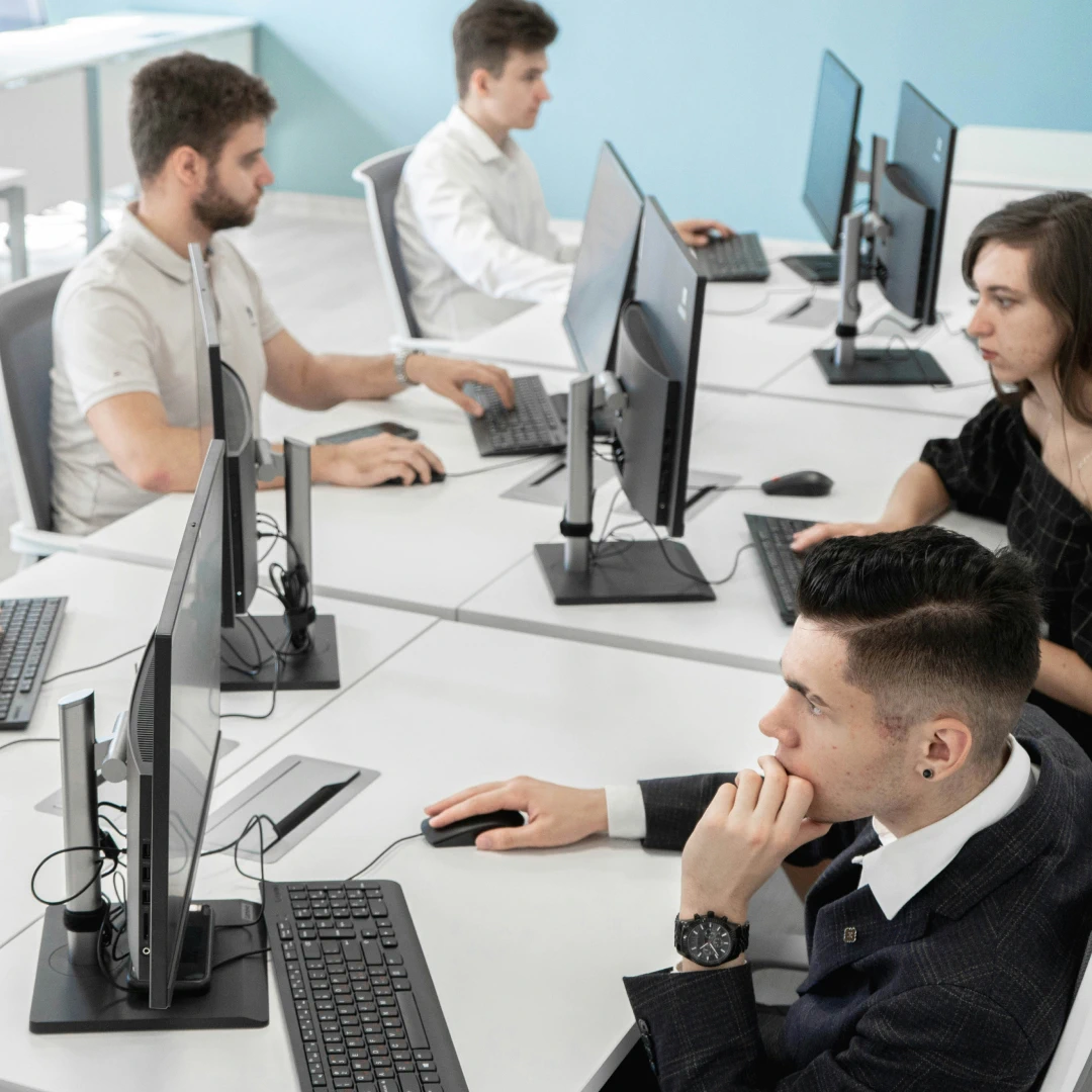 Customer support agents sitting at their workstations, working diligently at computers in a modern spacious call center