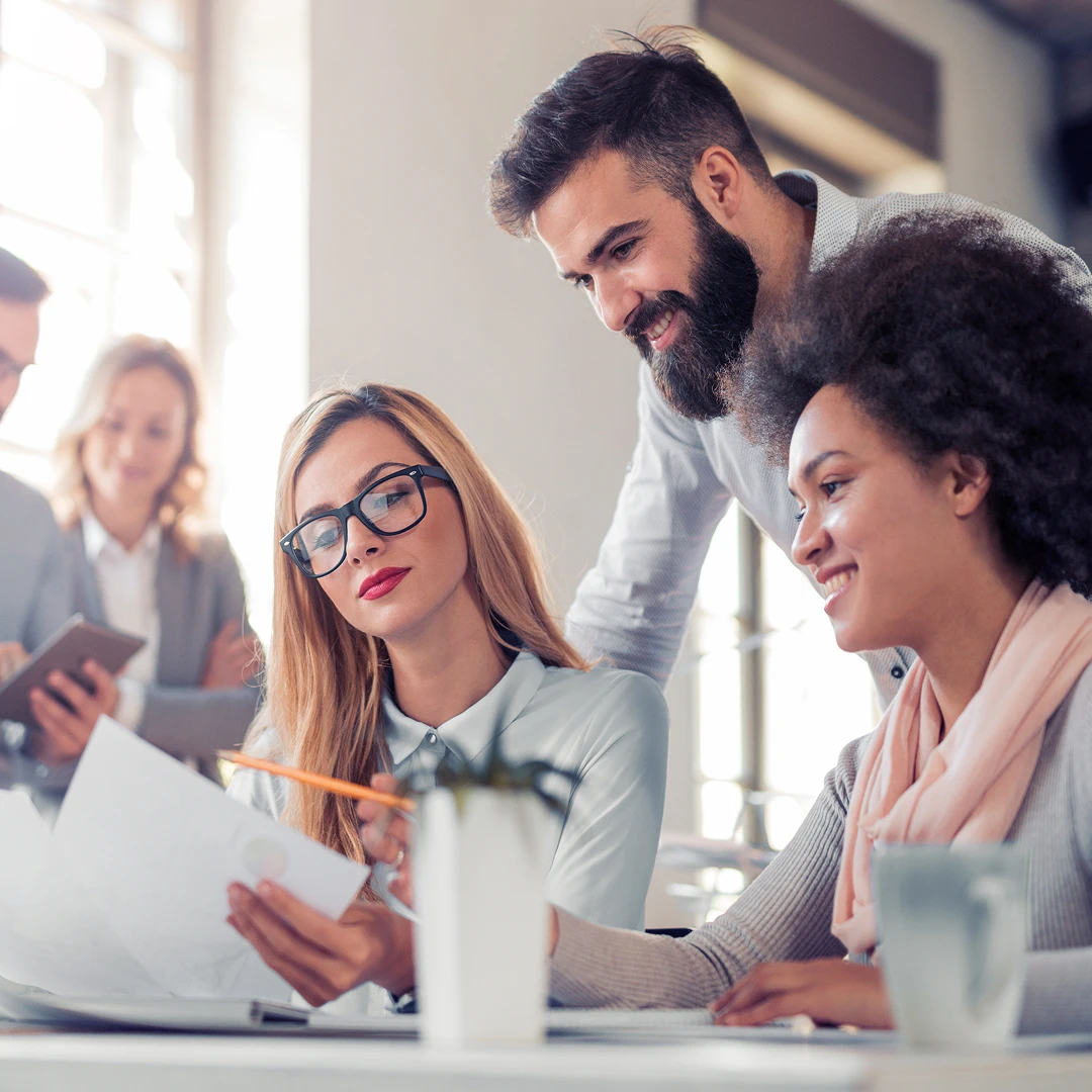A group of people working together on a document around a table