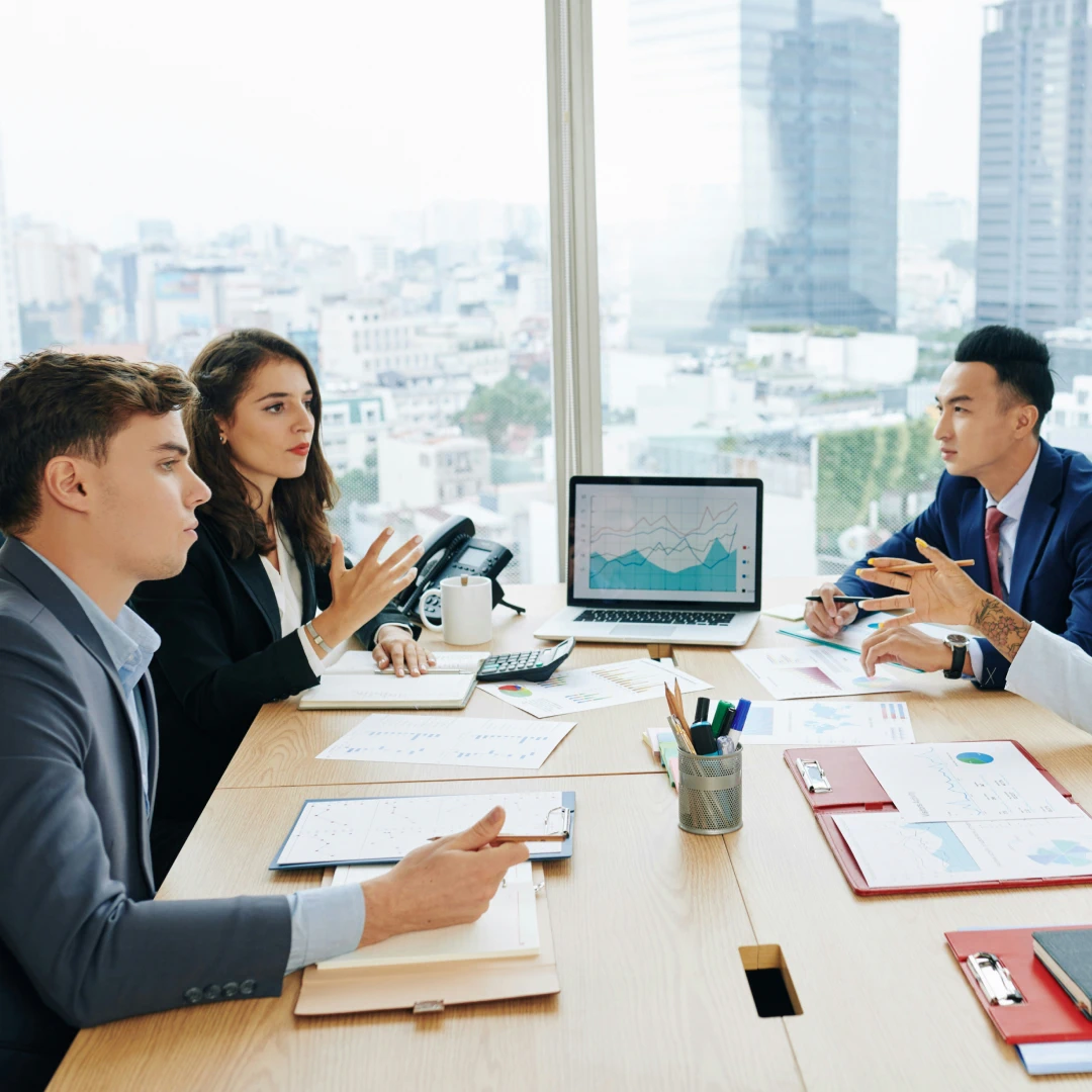 Business team discussing data analysis and strategy in a modern office with a cityscape view