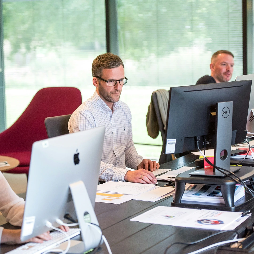 Group of customer support agents working at computers in a bright, spacious call center in Seattle