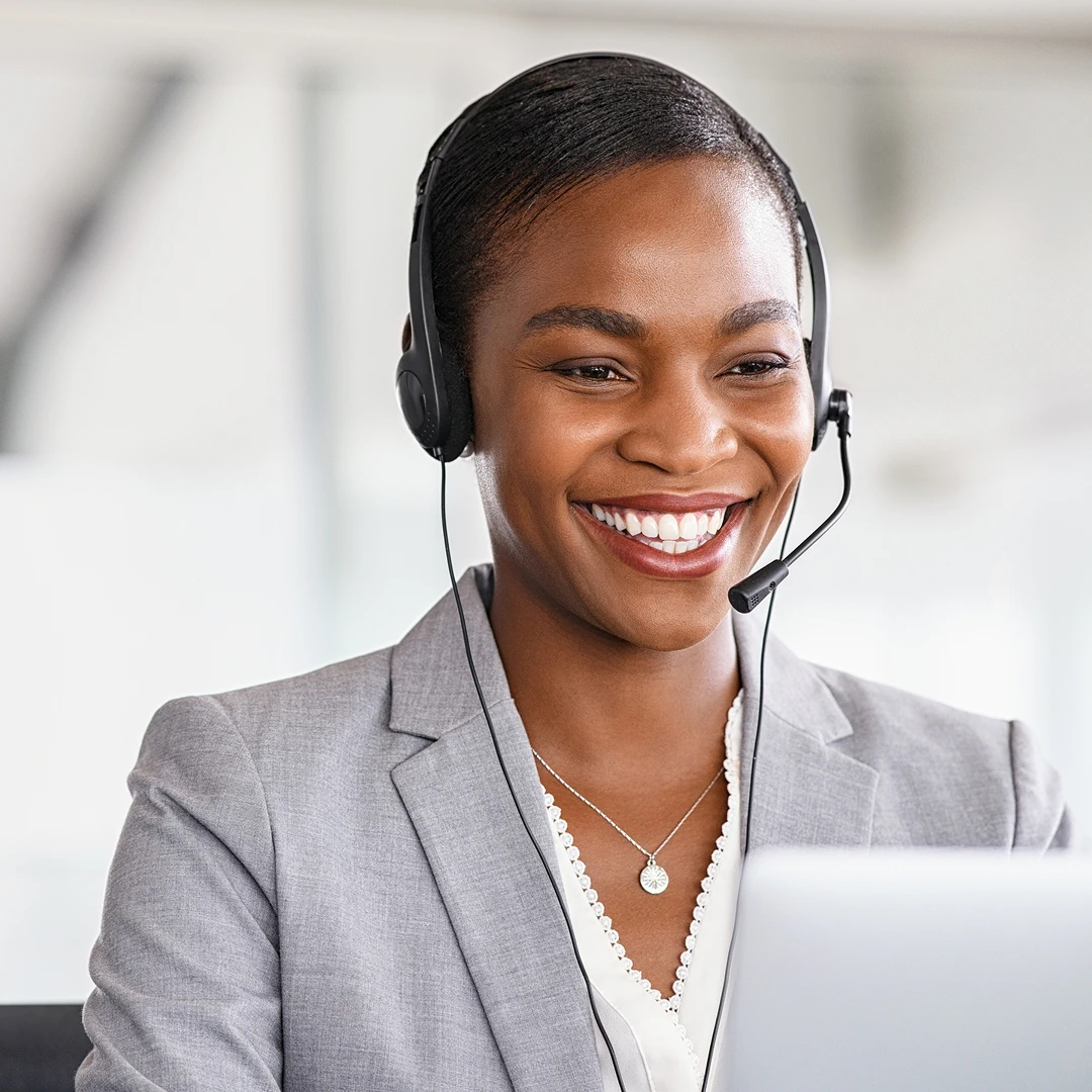 Friendly and professional female customer support representative wearing a grey blazer with a headset