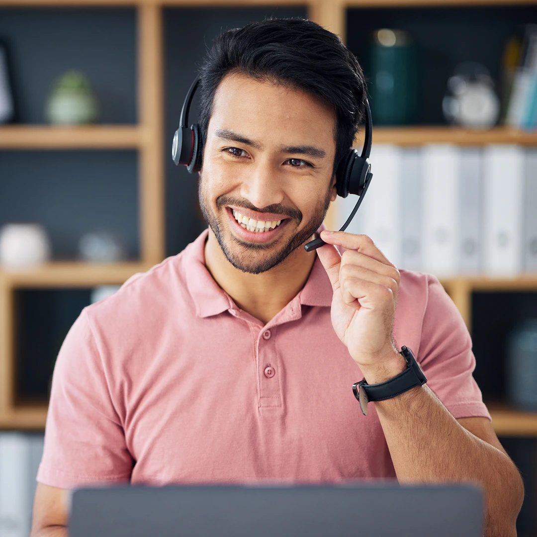 A friendly call center agent in the Philippines, wearing a headset, is helping a customer