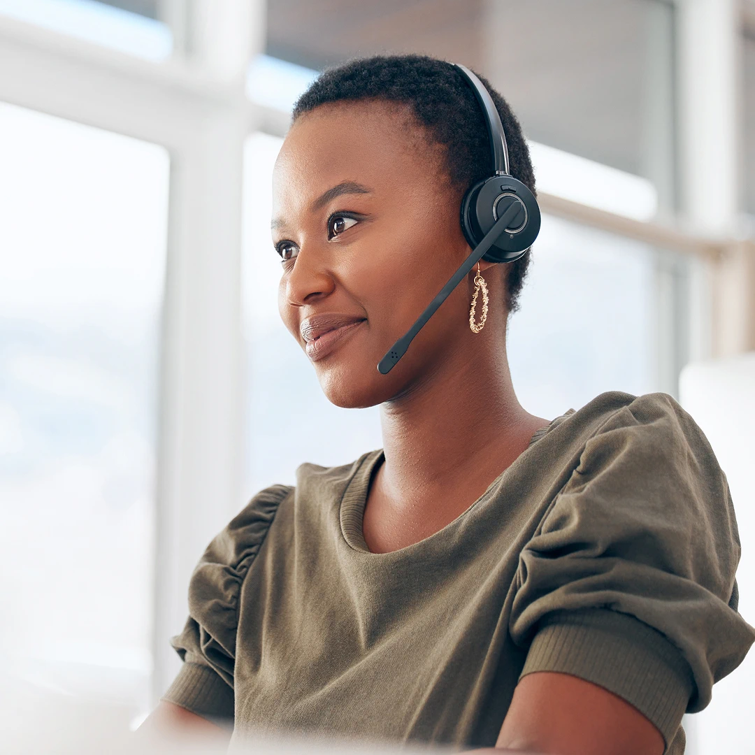 A woman with short black hair wearing a headset, providing professional customer support and assisting clients in South Africa