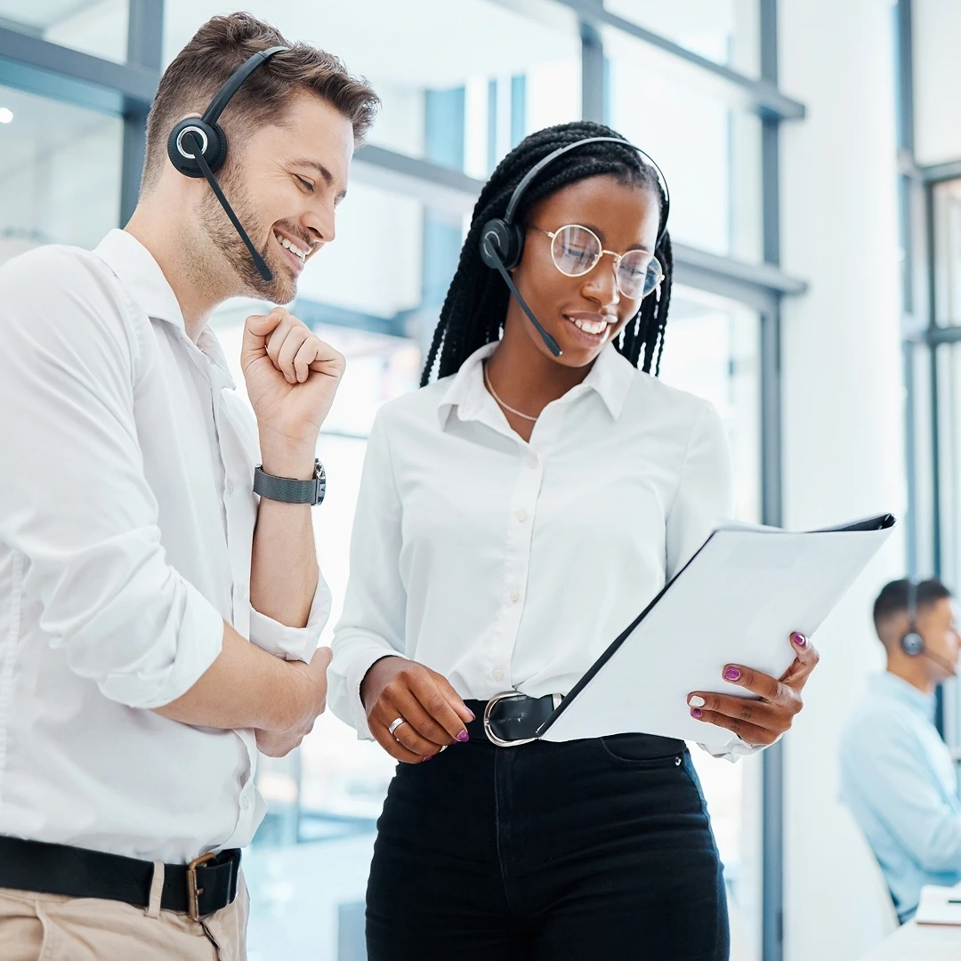 Male and female customer service agents looking at a document