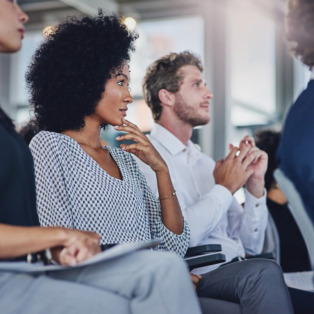 A group of diverse people listening attentively during a presentation or meeting