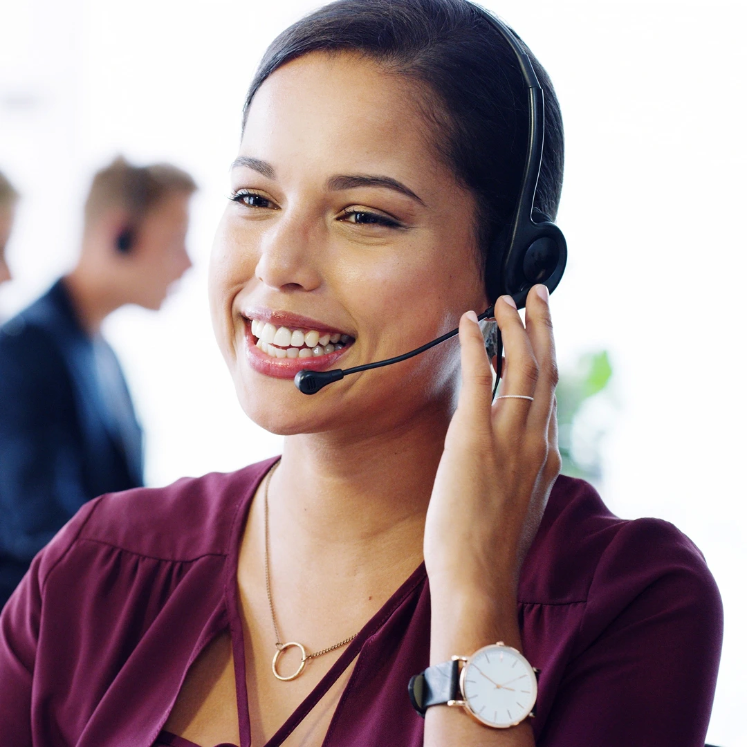 Cheerful customer support representative in a burgundy shirt with headset