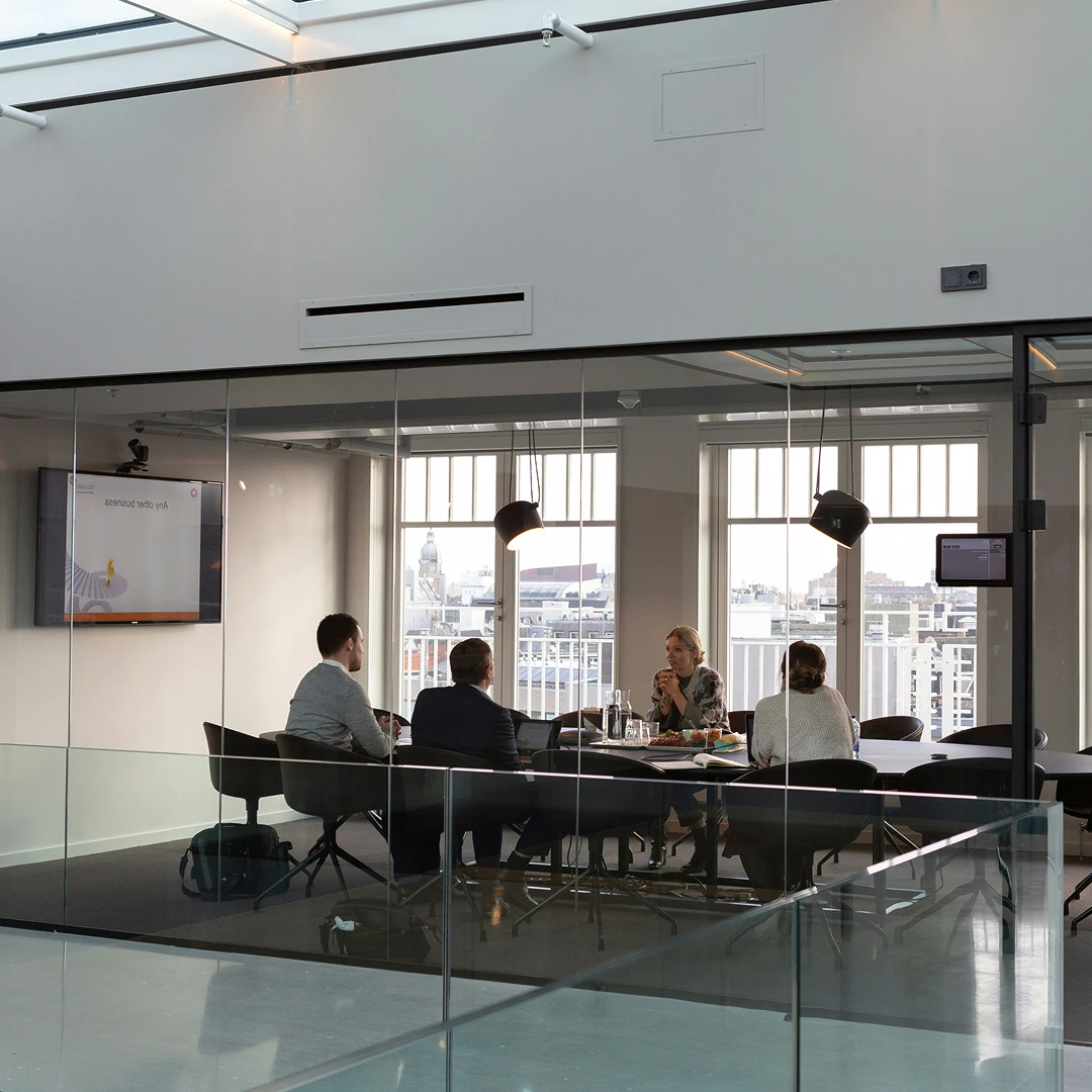 Business people engaged in discussion during a meeting in a modern conference room with glass walls