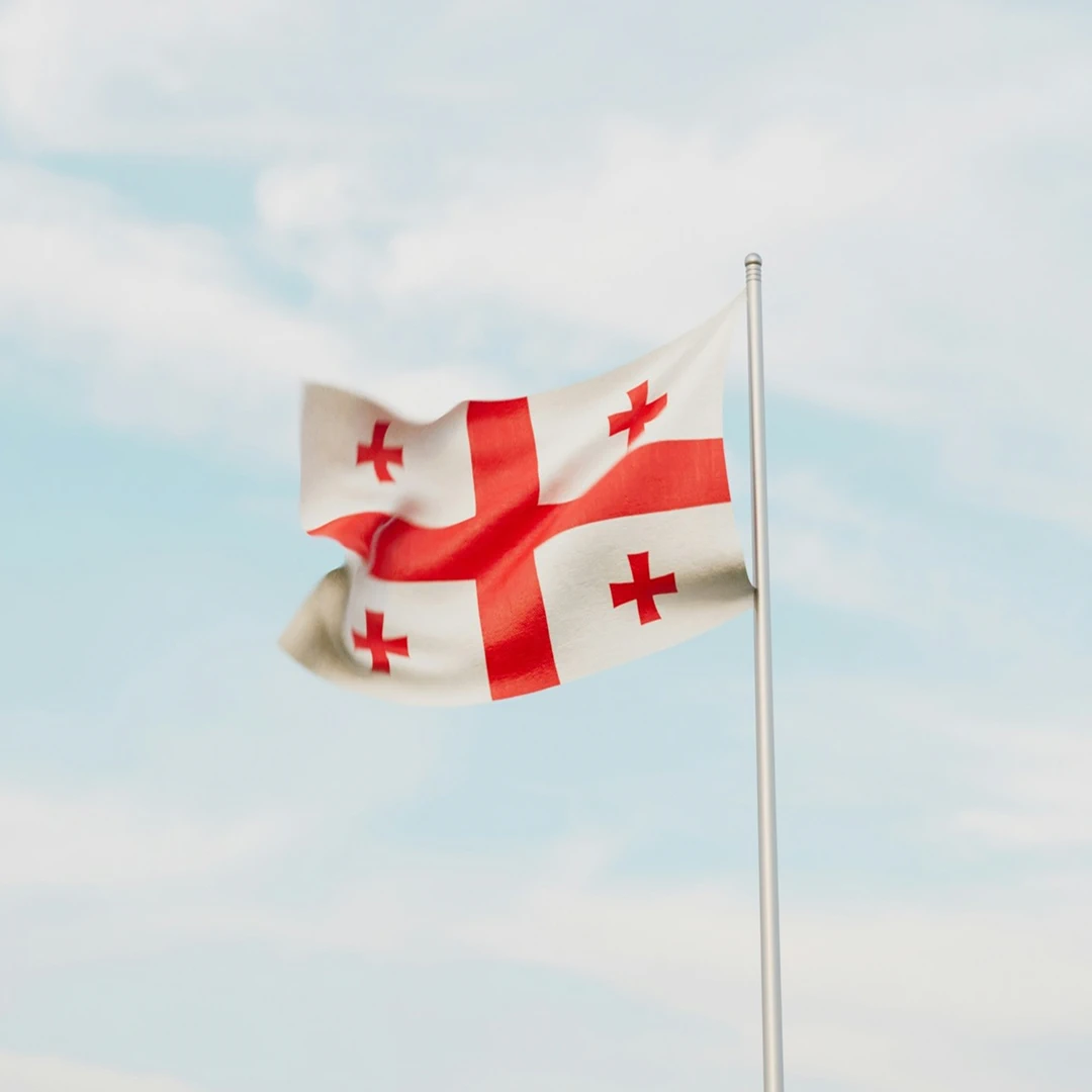 Georgian flag waving against a blue sky