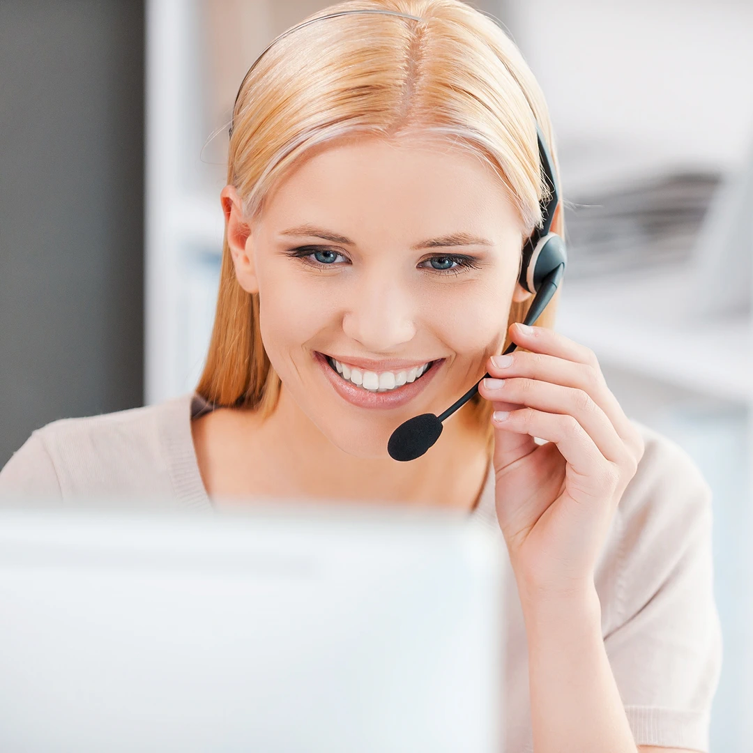 Smiling blonde female customer service representative with a headset, ready to assist
