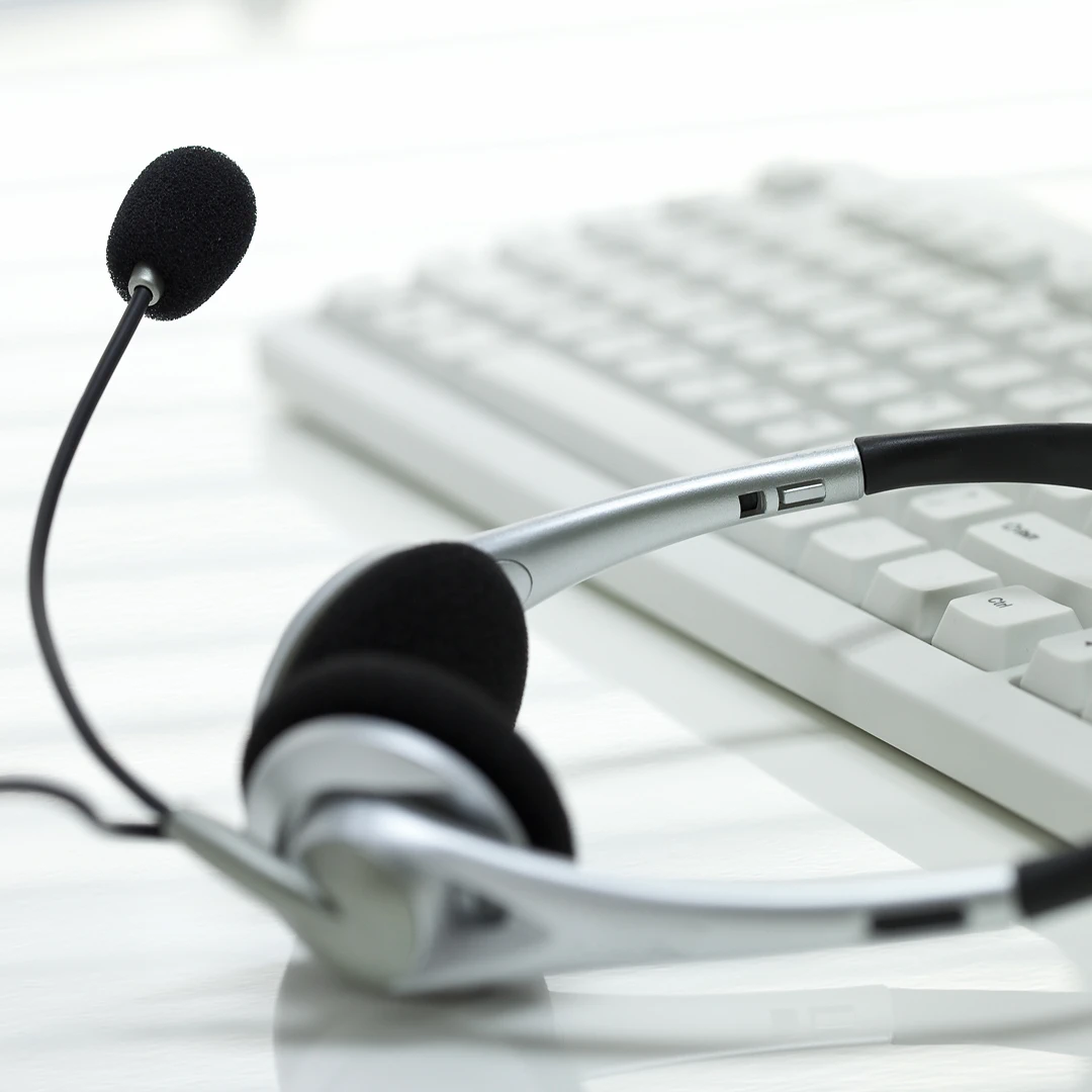 Headset and keyboard lying on a white table