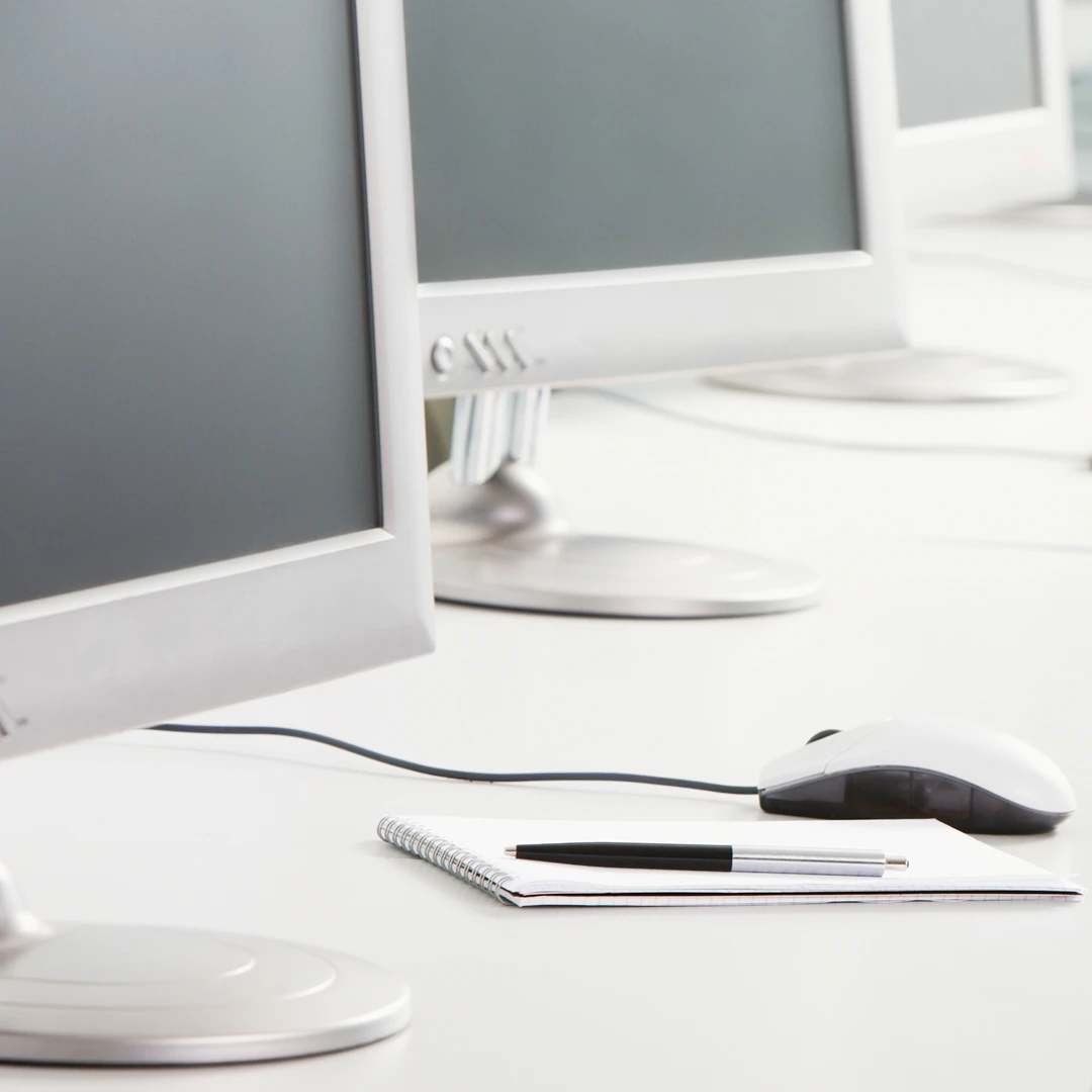 Clean and organized desk with computer setup and writing materials
