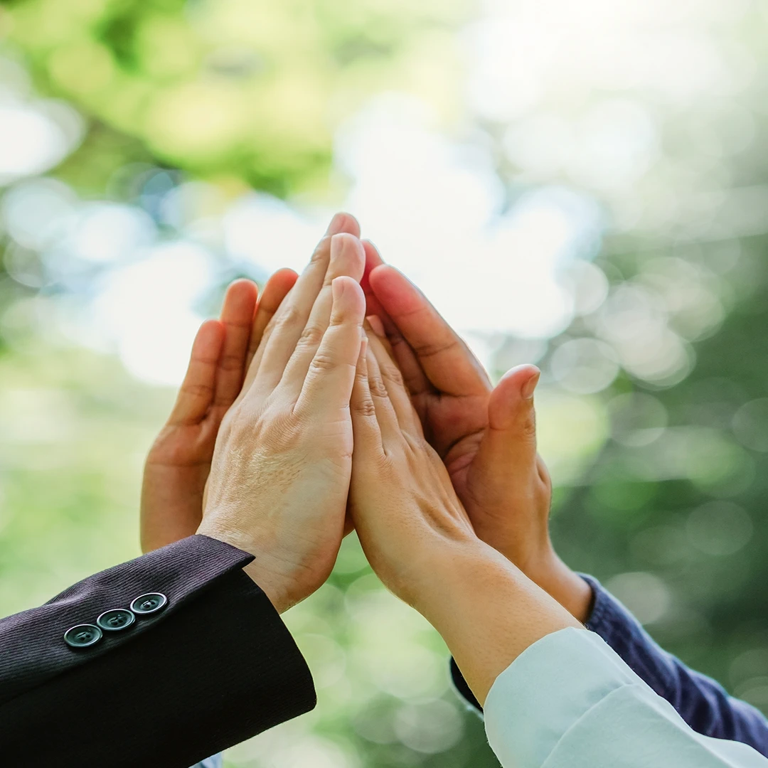 Several hands are shown coming together in a high-five formation