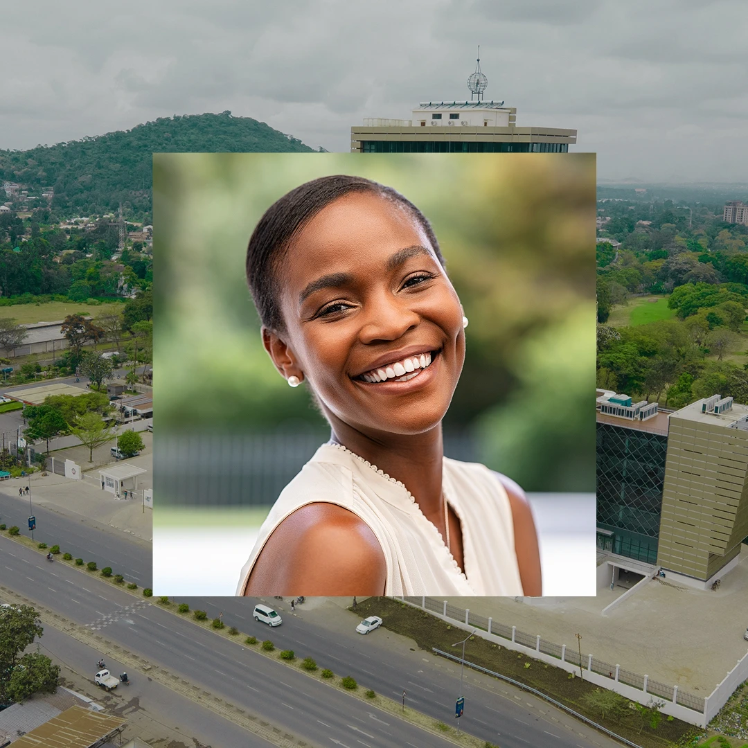 Smiling woman with short black hair, wearing pearl earrings