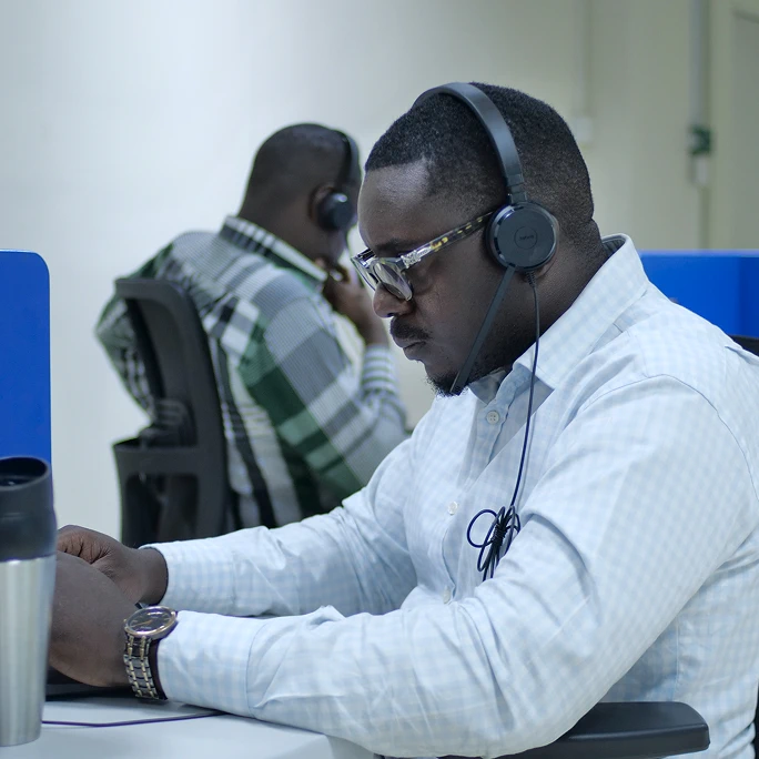 Professional Ugandan support agent assisting clients from a modern call center