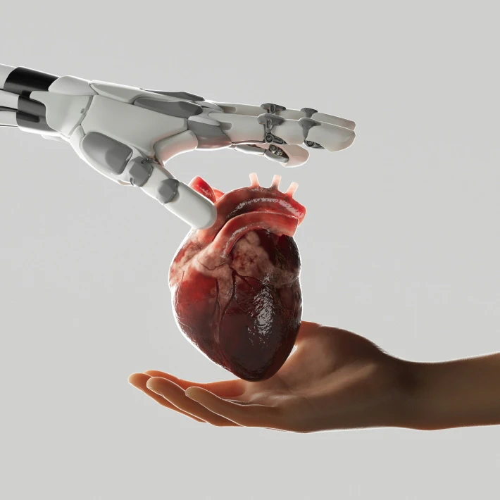 a robo hand and a human hand with a heart in the middle