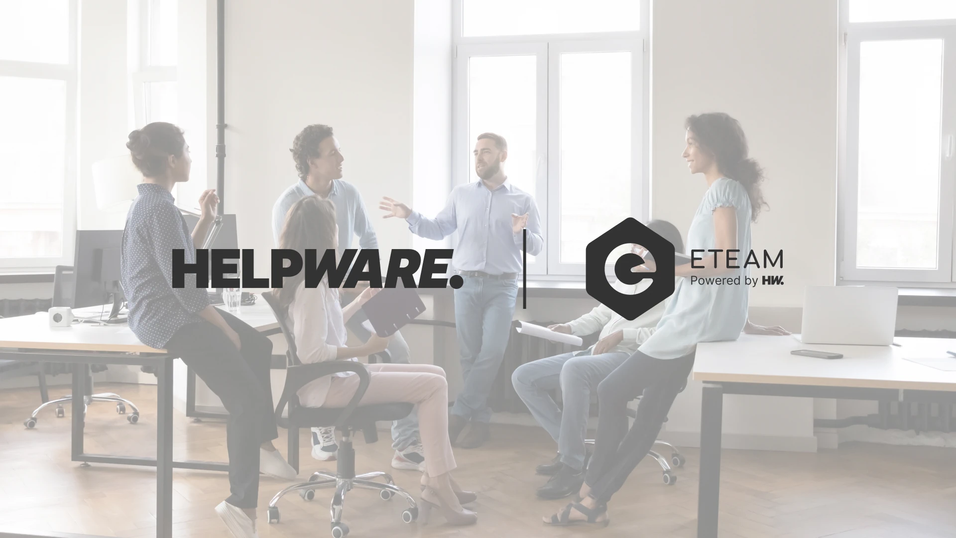 A group of six people is having a business discussion in a bright, modern office