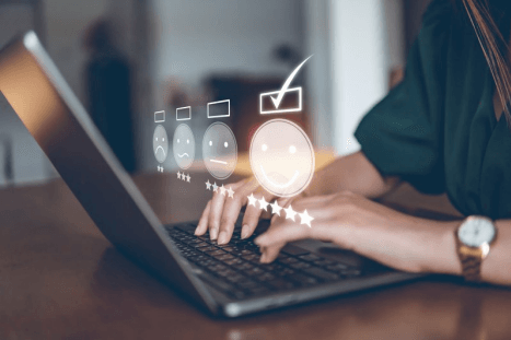 A woman typing on a laptop conducts a survey with a customer.