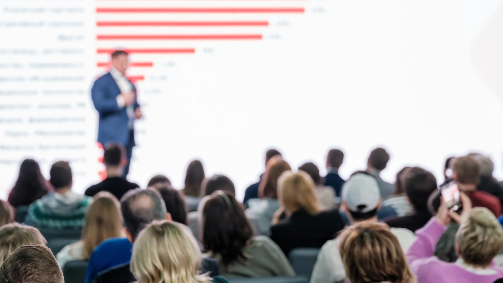 A speaker presenting to an audience at a conference.