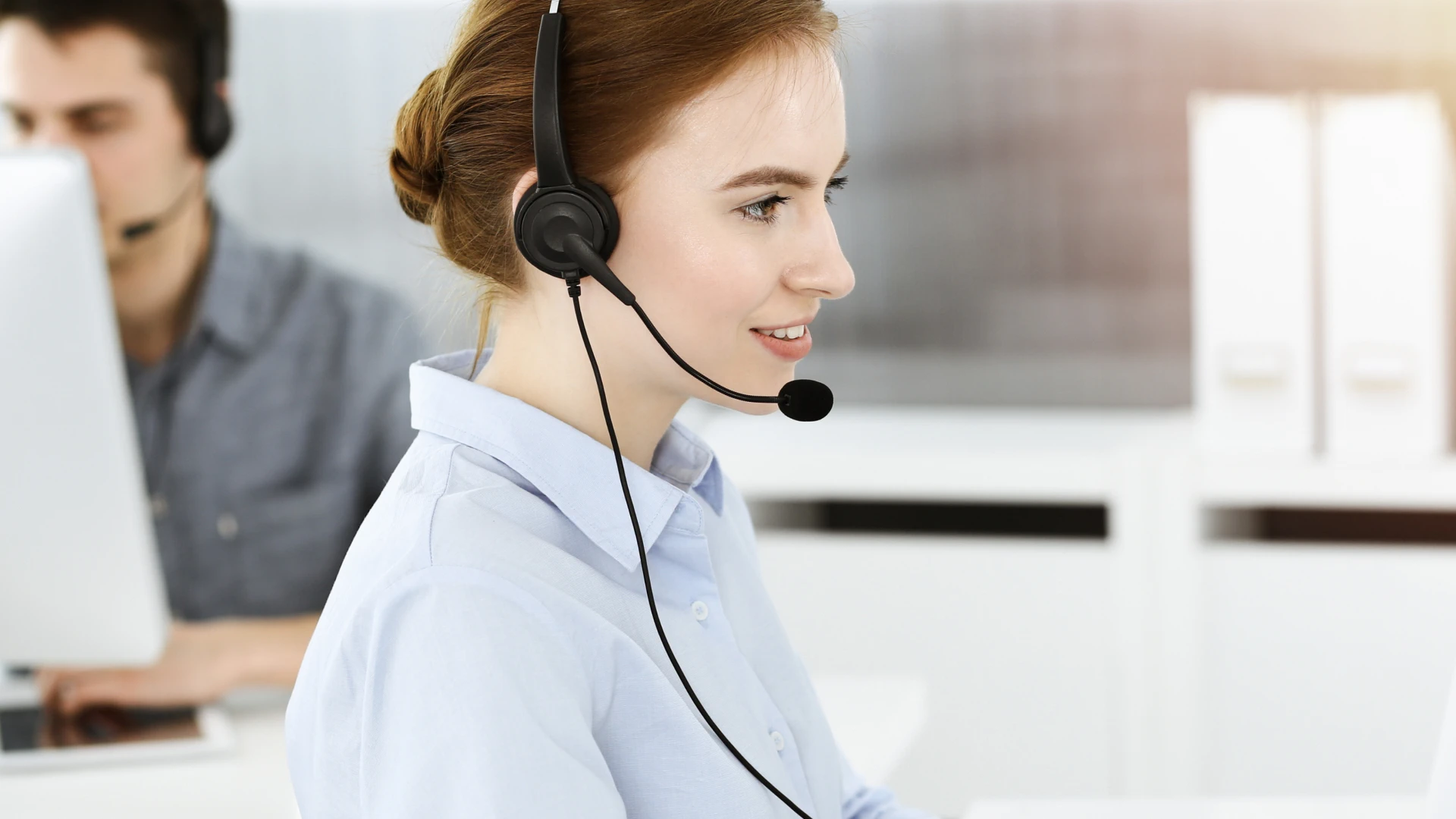 Smiling female customer service representative wearing a headset.