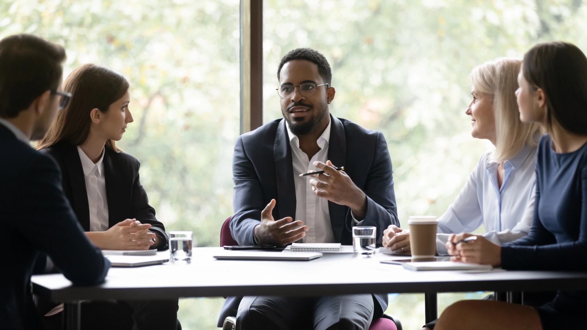 Team leader sharing ideas with coworkers during a business meeting.