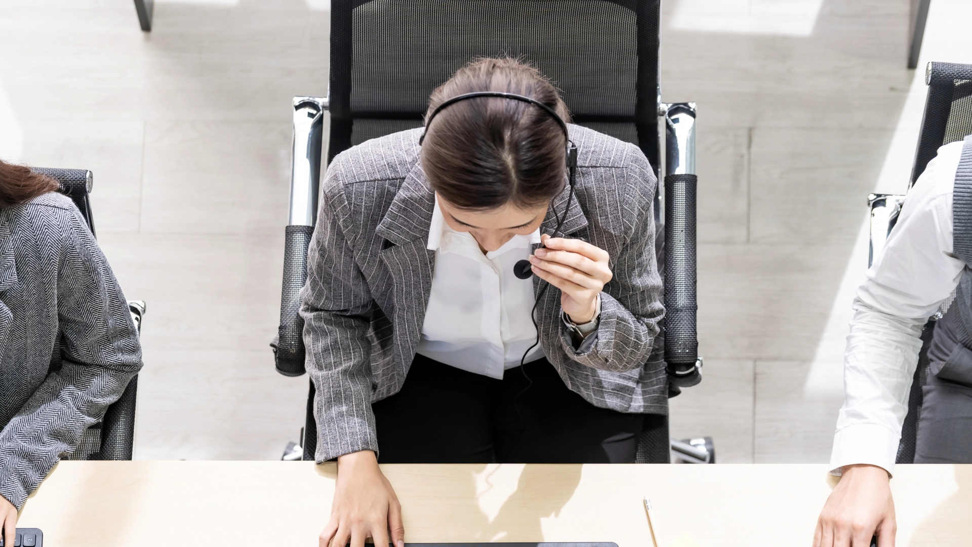 Overhead view of a customer service representative wearing a headset at their workstation.