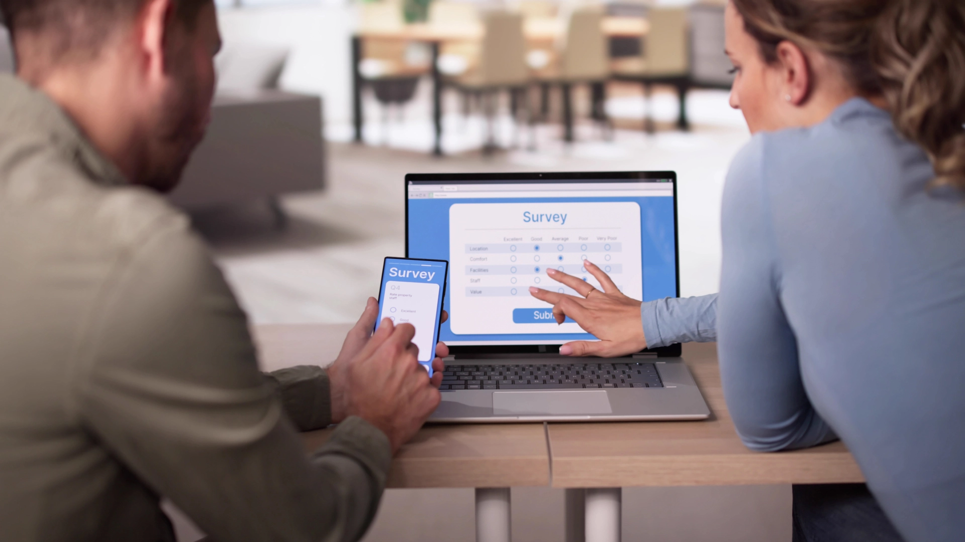 Two people filling out an online survey on a laptop and smartphone.