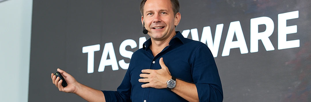 Man in a blue shirt speaking at a conference